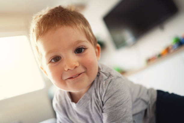 istock Playful toddler boy climbing on the sofa 1364015992