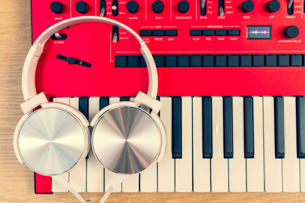istock white headphone on red synthesizer keyboard. music concept 1364016077