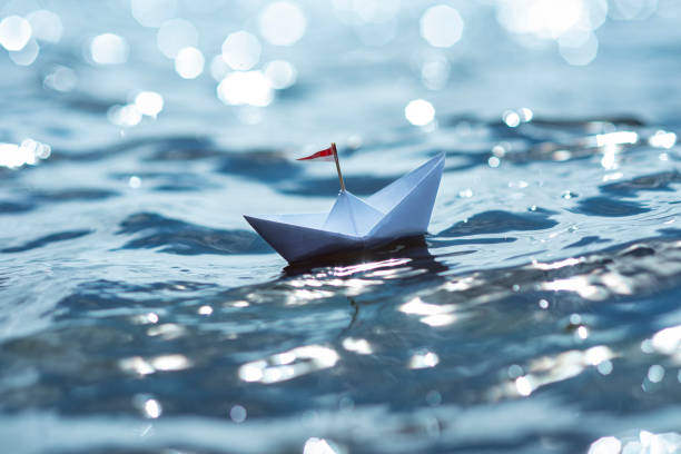 istock Paper ship in the glittering sea 1364016559