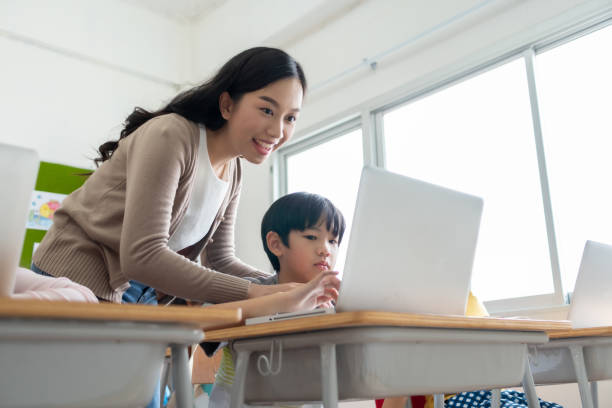 istock Asian woman teacher is teaching little boy learning on laptop 1364016702