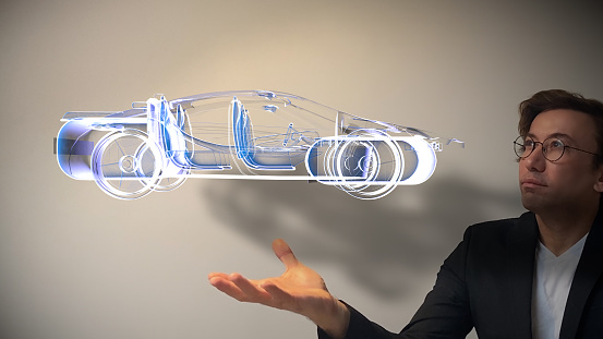 Genius designer showing next-generation hologram technology held in his hand. Augmented virtual reality is about to become a part of life in the near future. The new design technology enables all parts of the vehicles to be designed interactively, combining and separating them. You can see the animation movie of this image from my iStock video portfolio. Video number: 1363663253