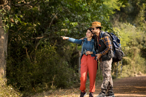 istock Couple with backpack hiking and admiring view in forest 1364021116