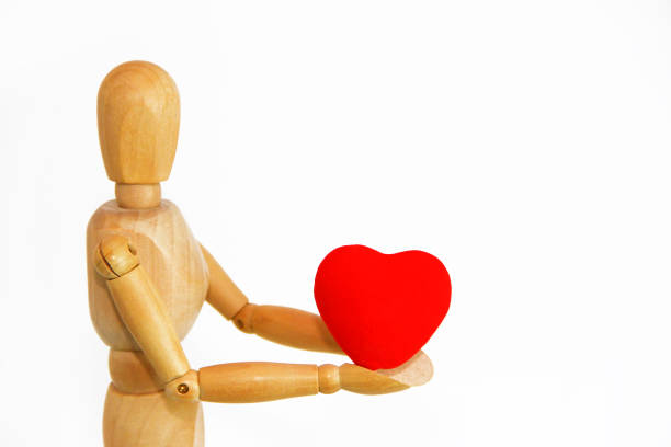 istock wooden mannequin holding a red heart 1364021221