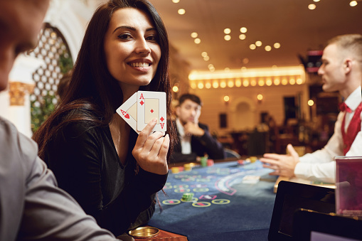 Girl with cards in her hands smiles rejoices at winning poker in a casino. Gambling Betting. Roulette.