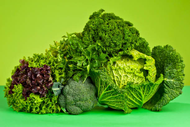 istock Cabbage, dill, lettuce, broccoli on a green background. Assorted vegetables in a pile. 1364024700