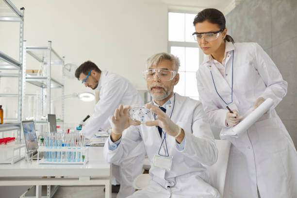 istock Two male and female scientists analyze samples working with chemicals in a laboratory. 1364024873