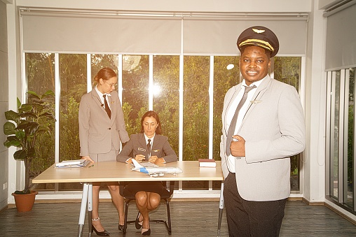 A flight attendant poses in his own workplace. Business aviation concept.