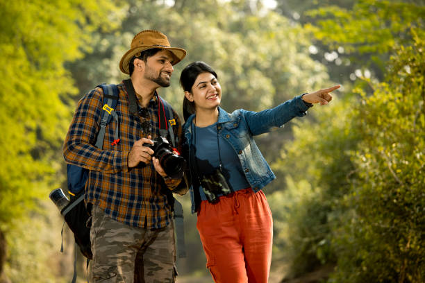 istock Young couple exploring nature and photographing with camera while hiking in forest 1364027588