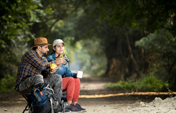 istock Couple drinking coffee and admiring nature in forest 1364028779