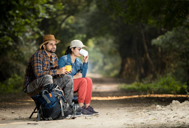 istock Couple drinking coffee and admiring nature in forest 1364028820