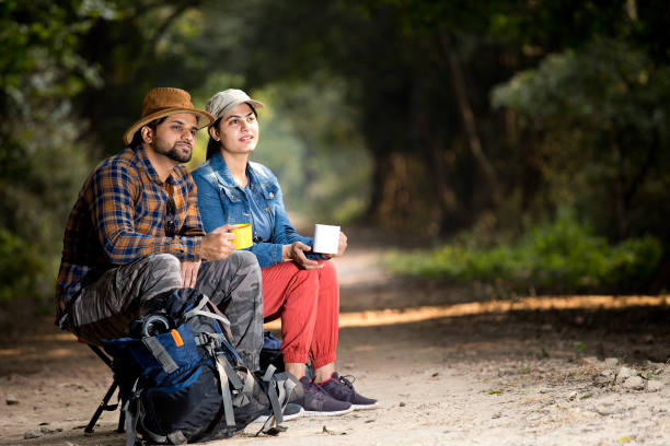istock Couple drinking coffee and admiring nature in forest 1364028851