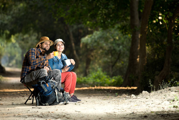istock Couple drinking coffee and admiring nature in forest 1364028885
