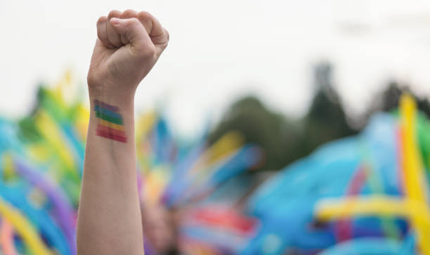 istock Raised up female arm with rainbow tattoo on it 1364029156