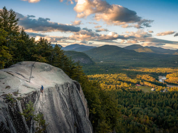 Climbing with a View A climber begins to descend down a mountain face at sunset in the White Mountains, New Hampshire. new hampshire stock pictures, royalty-free photos & images