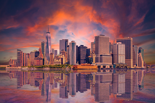 New York City Skyline with Manhattan Financial District, Battery Park, World Trade Center, Sail Boat, Staten Island Ferry and Dramatic Orange and Blue Sunset Sky with Clouds All Reflected in Water of New York Harbor, Canon EOS 6D Full Frame Sensor Camera and Canon EF 24-105mm f/4L IS USM Lens.