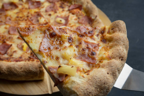 istock Delicious pizza slice with hawaiian pizza on dark background. 1364034260