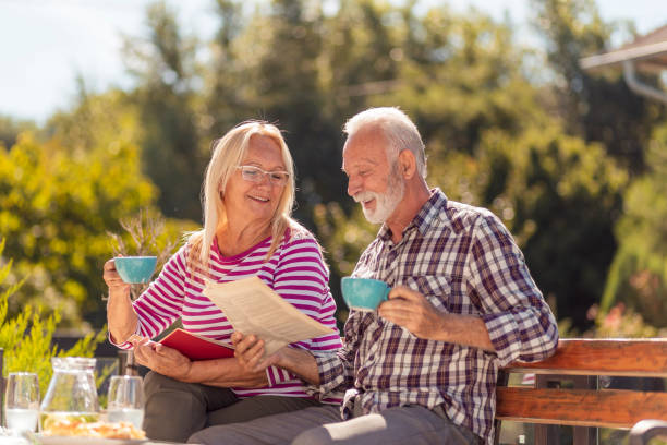 istock Senior couple drinking coffee and reading in the backyard 1364034262