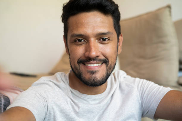 istock Latin bearded man sitting on floor against bed 1364036430