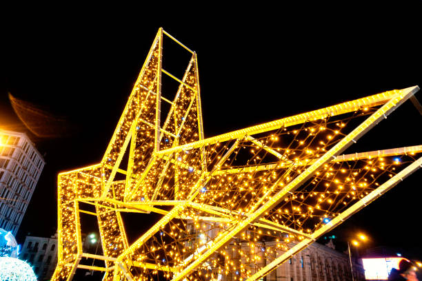 istock Glowing pointed yellow star hung with garlands 1364036570