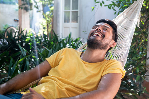istock Latin boy laughing out loud while lying on hammock 1364036914