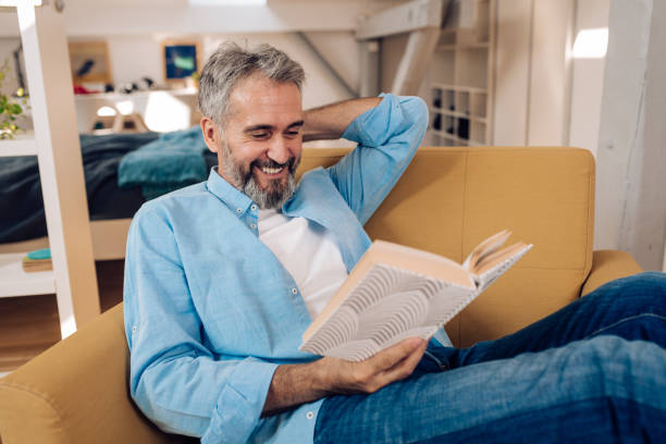 istock Senior man reading at his home 1364037077