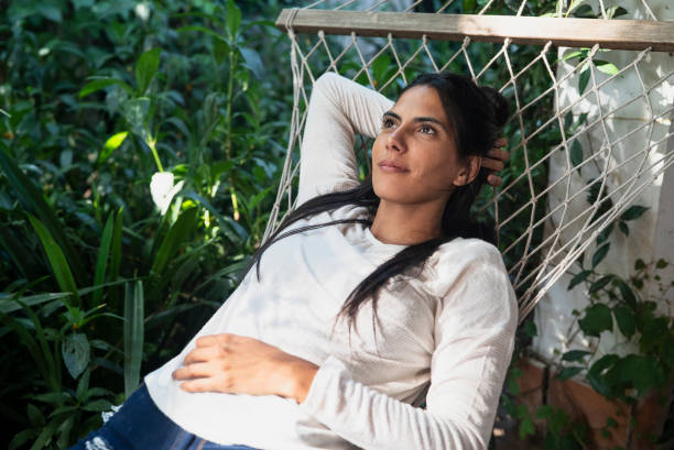 istock Mexican beautiful woman daydreaming while lying on hammock 1364038016