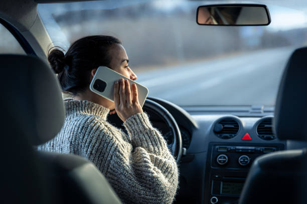 istock Young woman talking on the phone while driving a car. 1364038229
