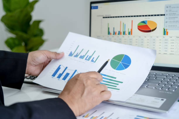 istock Asian accountant working and analyzing financial reports project accounting with chart graph in modern office, finance and business concept. 1364040370