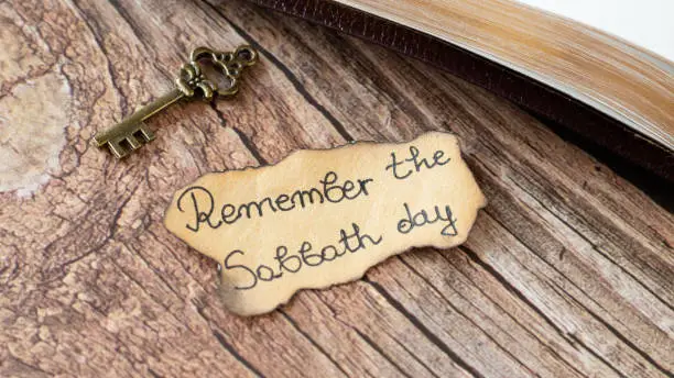 Photo of Remember Sabbath Day handwritten quote on ancient, old-fashioned paper