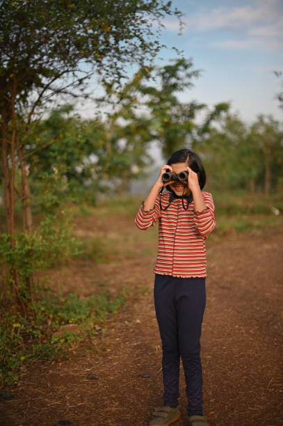 istock Girl looking through Binoculars in nature 1364050904