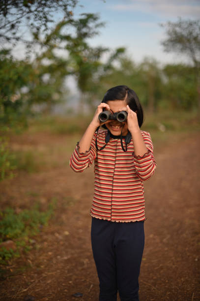 istock Girl looking through Binoculars in nature 1364050964
