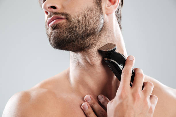 istock Cropped image of a bearded man using electric razor 1364054694