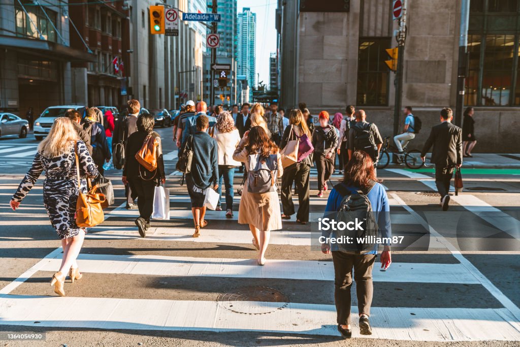 Crowd of unrecognisable people crossing street on traffic light zebra Crowd of unrecognisable people crossing street on traffic light zebra in the city of Toronto at rush hour - Lifestyle in a big city in North America People Stock Photo