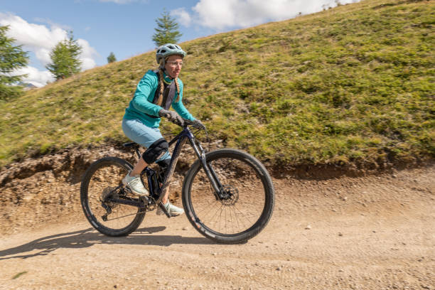 istock Female mountain biker rides along trail in Summer, downhill 1364057242