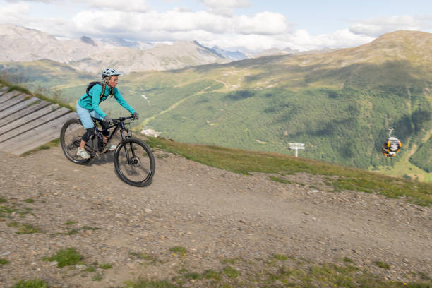 istock Mountain biker on curvy wooden track, mountains 1364057269