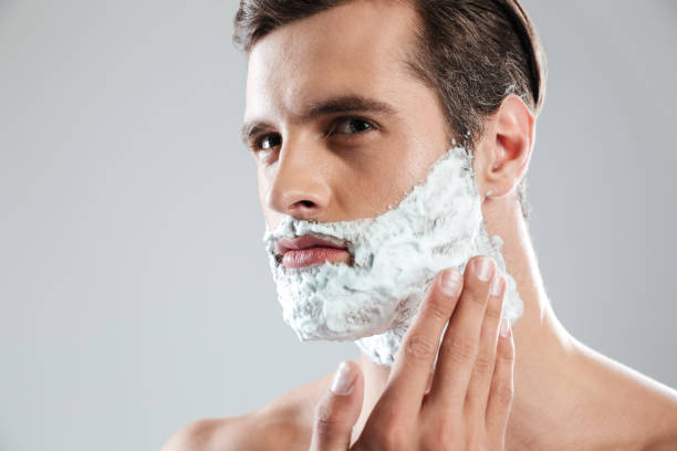 istock Concentrated man standing isolated with shaving foam on face 1364057295