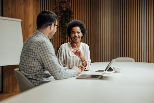 istock Happy business colleagues sitting in a modern office, while having a a conversation. 1364057915