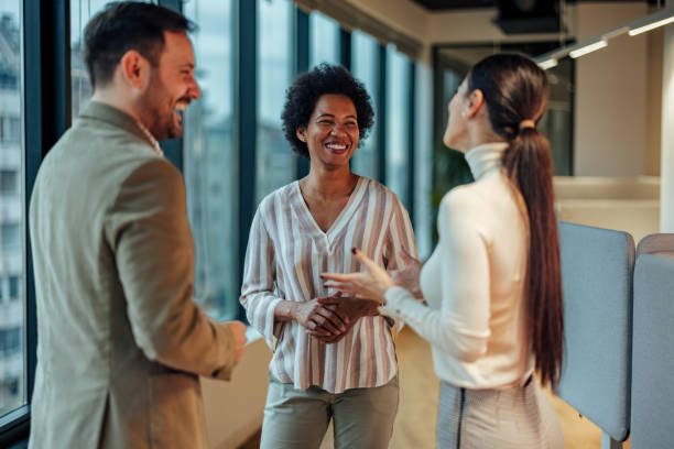 istock Smiling group of coworkers, talking about their weekends before starting work. 1364059950