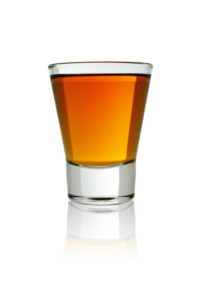 small shot glass of whiskey. isolated on a white background, close-up with reflection - russian shot imagens e fotografias de stock
