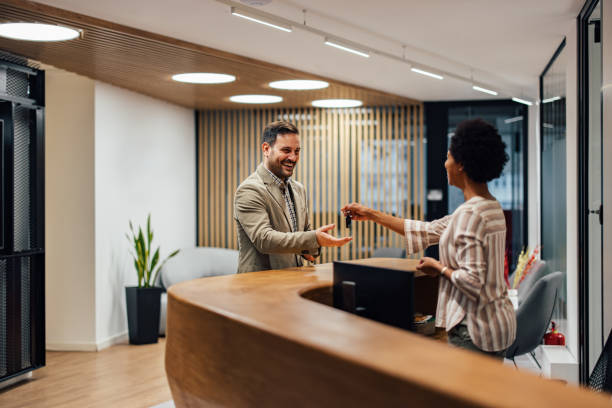 istock Excited caucasian man, taking a key from african-american receptionist. 1364061729