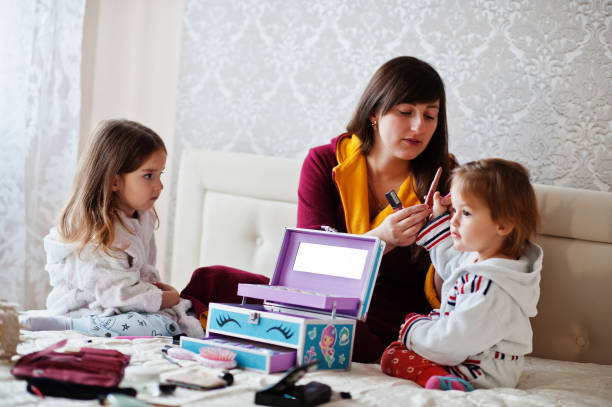 istock Mother and daughters doing makeup on the bed in the bedroom. 1364064419