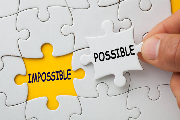 Impossible Is Possible Concept Hand holding missing jigsaw puzzle piece with text Possible, covering text Impossible. chance stock pictures, royalty-free photos & images