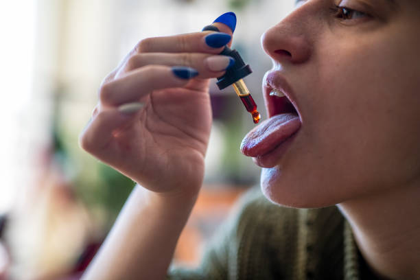 istock Woman taking cannabis drops. 1364066408