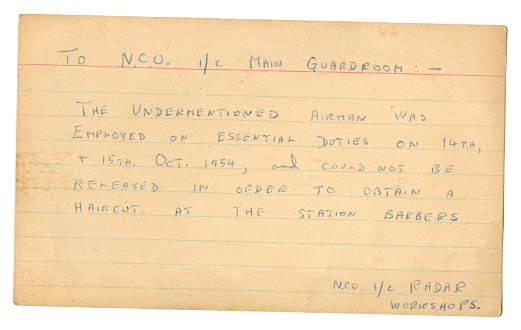 A card from an RAF Non-Commissioned Officer (NCO) in Charge, Radar Workshops, to the NCO in Charge, Main Guardhouse, explaining why a particular airman was unable to be released in order to obtain a haircut at the station barbers because he was employed on essential duties on the 14th and 15th October 1954. (Identifying details removed.)