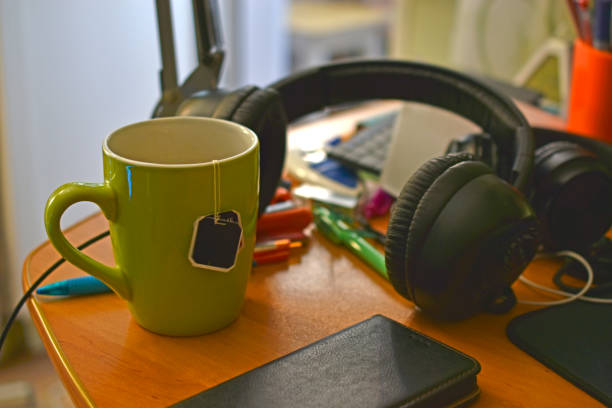 istock Home desk with tea cup and writing supplies 1364067109