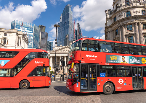 London, UK - Modern double-decker buses passing at an intersection in the City of London.