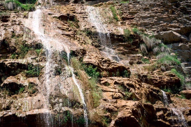 Beautiful natural background of falling water from a stone mountain.