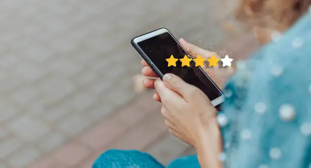 Photo of Customer review good rating concept.Excellent. Person using mobile phone with icon 4 star symbol to increase rating of company