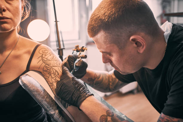 istock Making Japan Style Tattoo on customers shoulder 1364071077