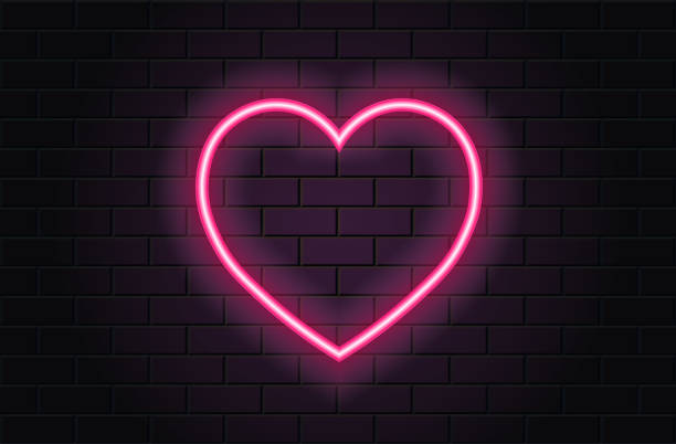istock Pink neon heart for valentines day on black brickwall background 1364071367